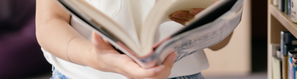 menina com um livro nas mãos em um biblioteca