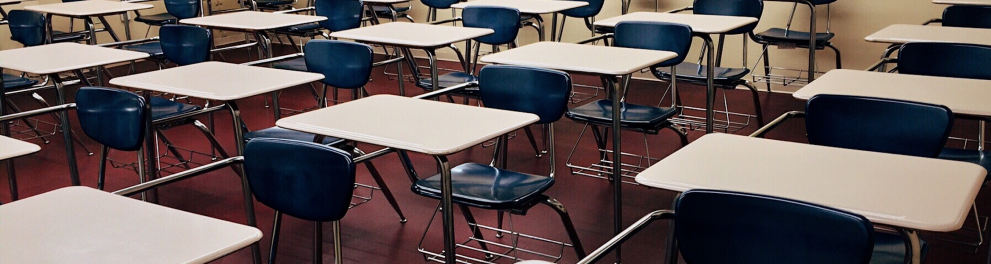 mesas e cadeiras desocupadas em uma sala de aula sem alunos