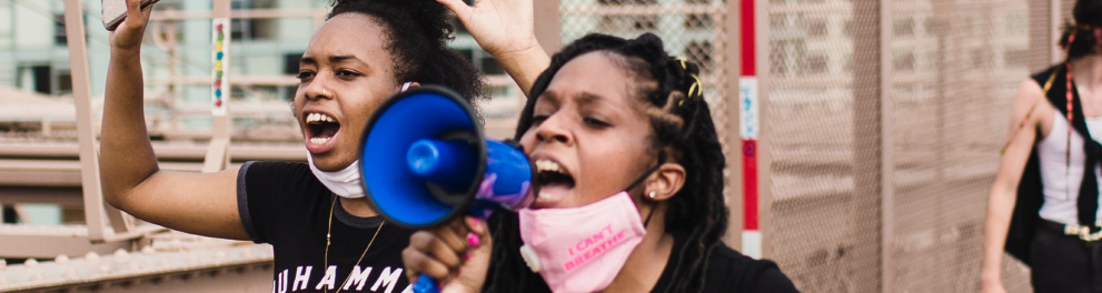 Duas mulheres negras estão se manifestando.