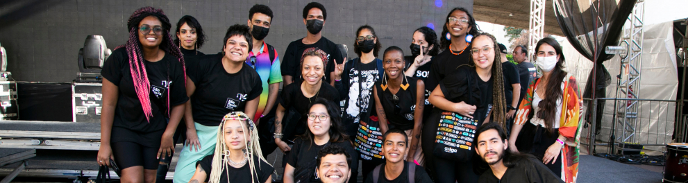 Jovens reunidos, sorrindo, em um palco.