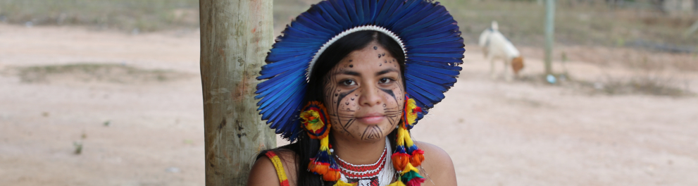 Uma mulher indígena olhando para a câmera