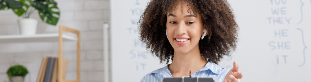 Uma mulher negra sorri enquanto interage com um celular.