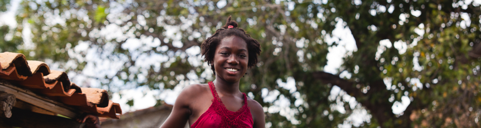 Uma criança negra sorrindo para uma foto