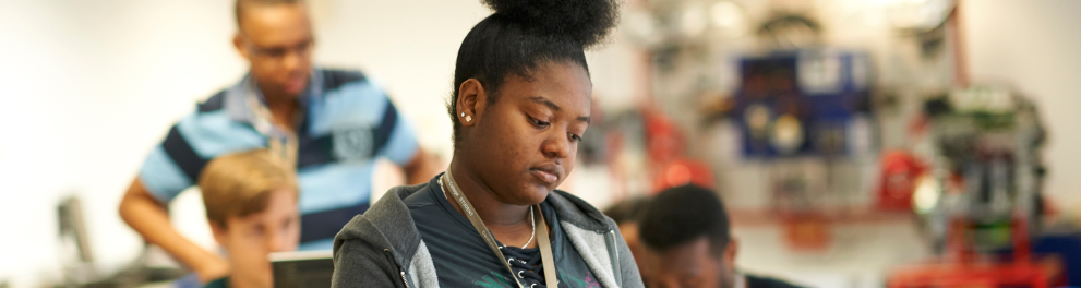 Uma mulher negra lendo em uma sala de aula