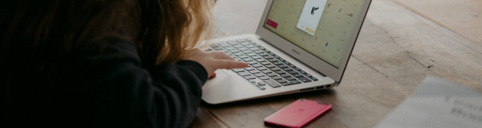 Uma menina jovem mexendo em um notebook