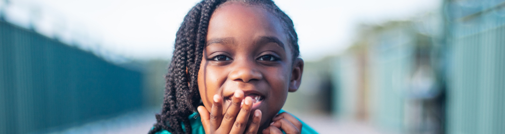 Uma criança negra sorrindo para uma foto