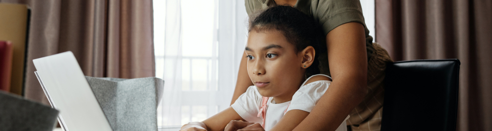 A imagem mostra uma mãe estudando com sua filha