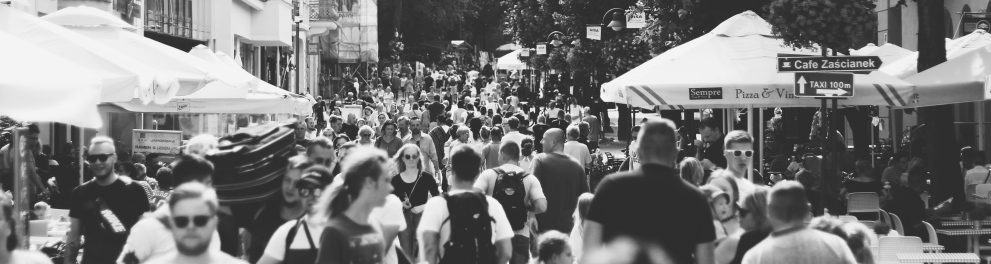 Diversas pessoas em uma rua. A imagem está em pretro e branco.