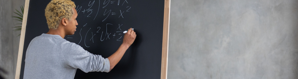 Imagem mostra um rapaz resolvendo contas matemáticos em quadro negro