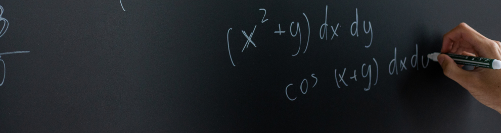 Imagem mostra uma Mão escrevendo no quadro negro