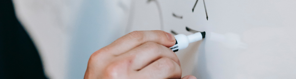 Imagem mostra uma mão em quadro branco