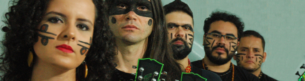 Os cinco integrantes da banda metaleira Arandu Arakuaa enfileirados, com uma mulher à frente e quatro homens seguindo a fila. Todos com os rostos devidamente pintados com a arte indígena
