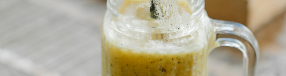 Um jarro com suco de maracujá revela o líquido amarelo e os pequenos caroços pretos dentro dele.