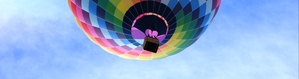 Um balão colorido flutua no céu.