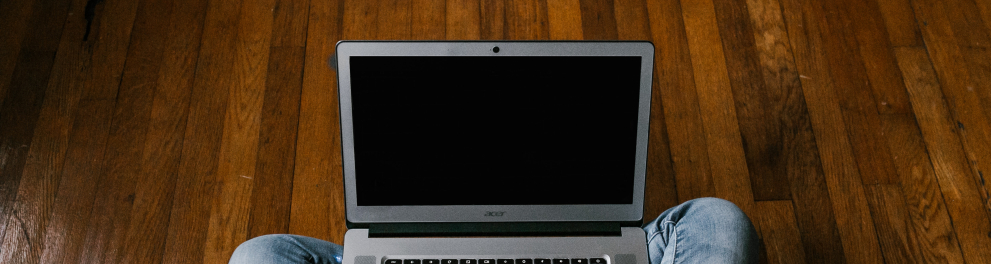 Imagem mostra uma pessoa digitando em notebook sobre o colo.