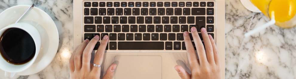 Imagem mostra mãos sobre notebook.