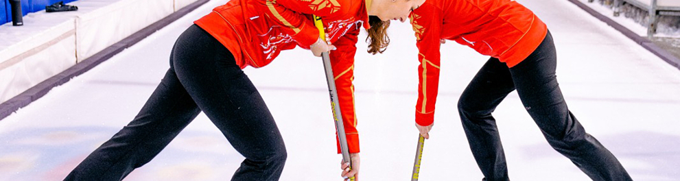Imagem mostra duas mulheres durante a pratica do esporte curling