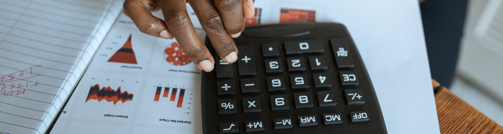 Imagem mostra uma pessoa Segurando Calculadora De Mesa Preta