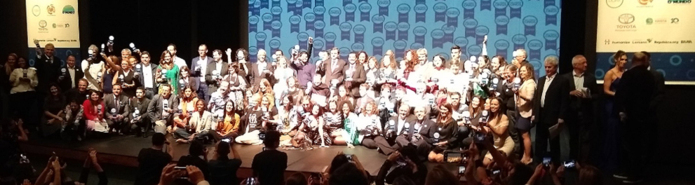 Imagem de várias pessoas em um palco durante a cerimônia de alguma premiação