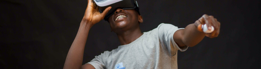 Um homem negro usando um óculos de realidade virtual e sorrindo