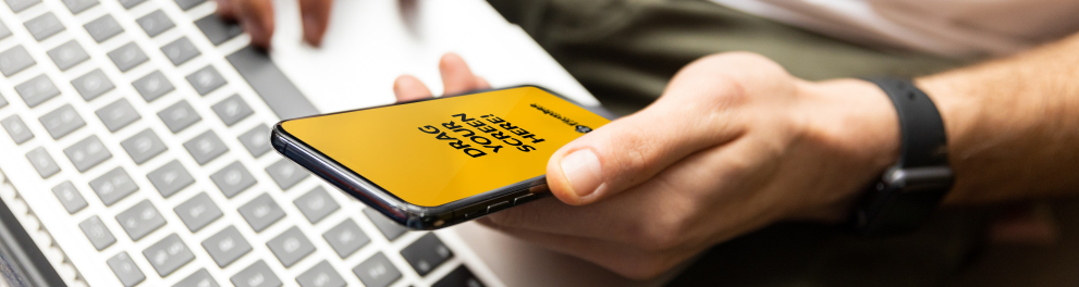 Um homem usando um notebook e um smartphone