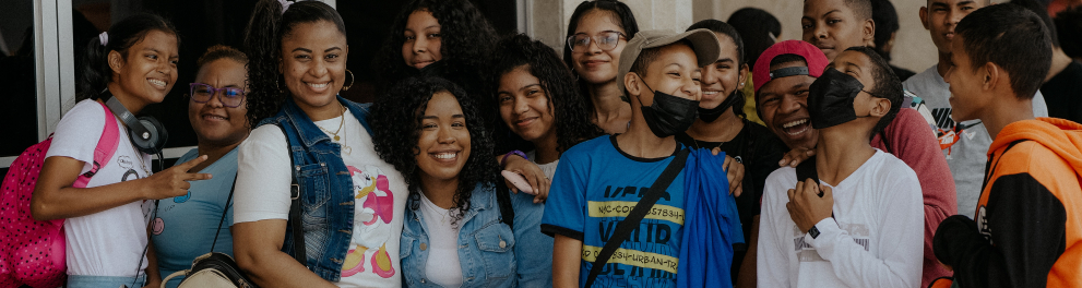 Mais de uma dezena de jovens estão lado a lado posando pra foto. Alguns de máscaras de prevenção à covid-19