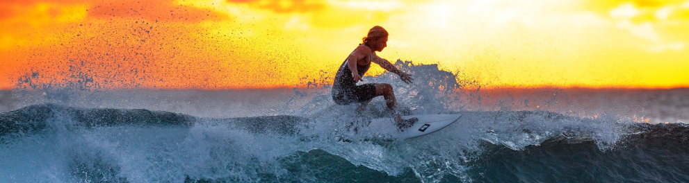 Uma pessoa está surfando em um dia que parece estar terminando.