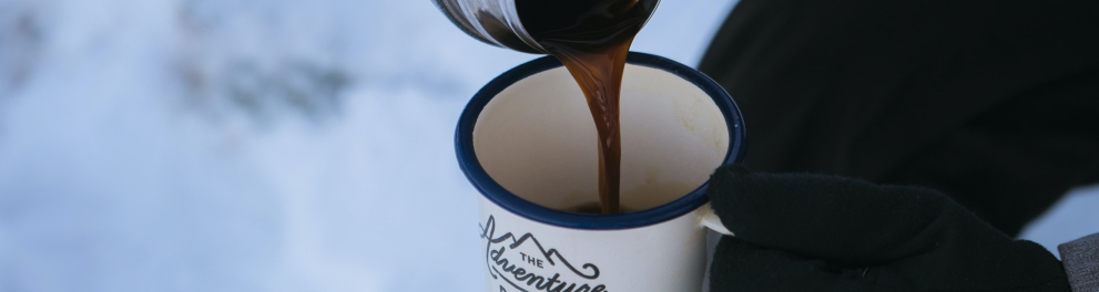 Imagem mostra uma xícara de café em meio a neve