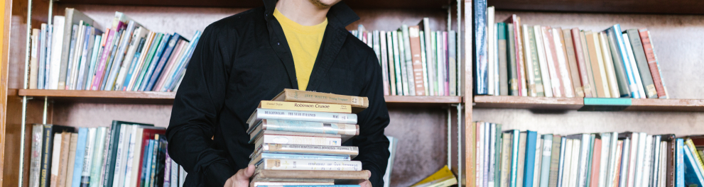 Imagem mostra um garoto segurando livros
