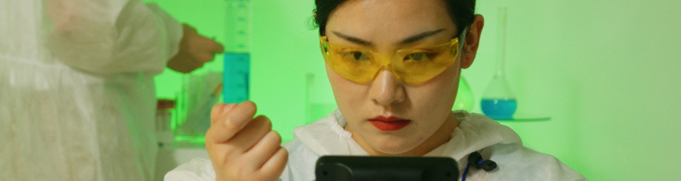 Imagem mostra uma mulher manuseando um tubo de ensaio