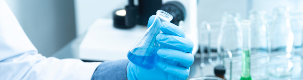 Imagem mostra uma mão de cientista segurando um tubo de ensaio