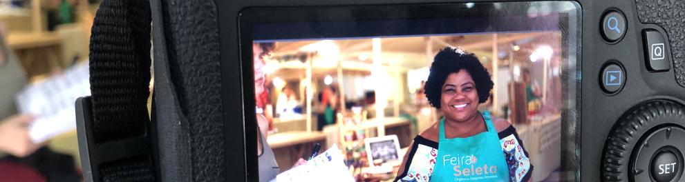 A imagem mostra uma câmera com uma foto no visor dos bastidores da série Acerte O Passo