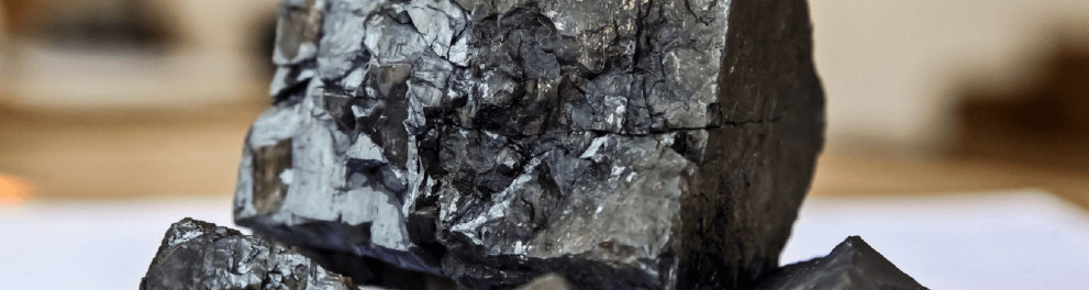 Imagem de uma pedra grande de manganês com pequenas pedrinhas do mesmo tipo à sua frente