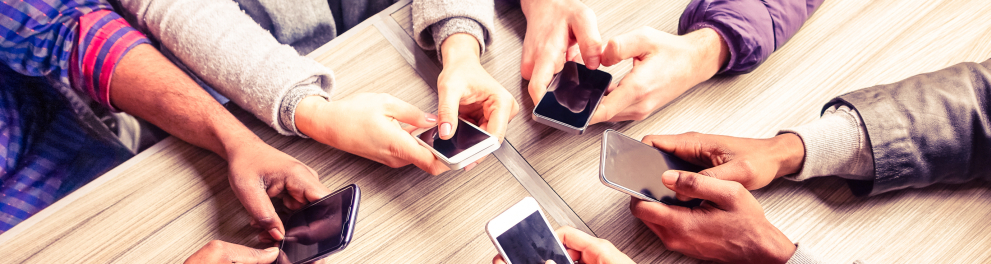 Várias pessoas segurando celulares em cima de uma mesa