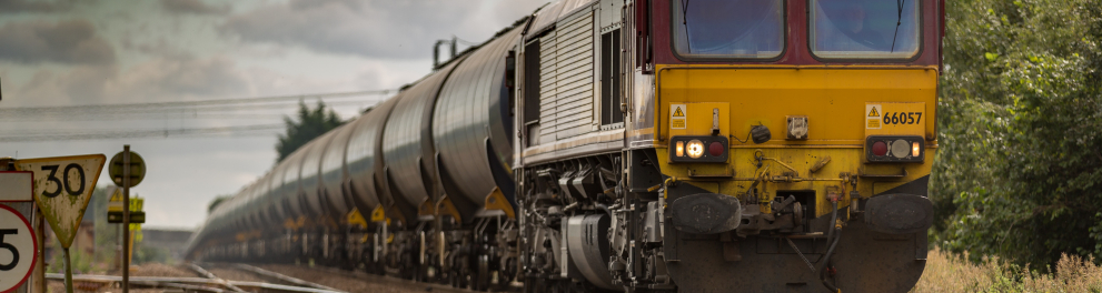 Um trem amarelado em movimento pelos trilhos
