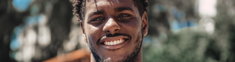 Um rapaz negro sorrindo para a foto