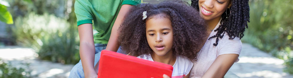 Duas crianças e uma mulher usando um tablet