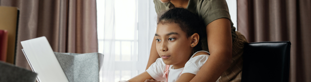 Mãe ajuda a filha no computador