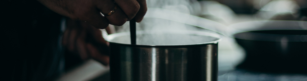 Imagem mostra uma mão segurando um utensílio mexendo em uma panela