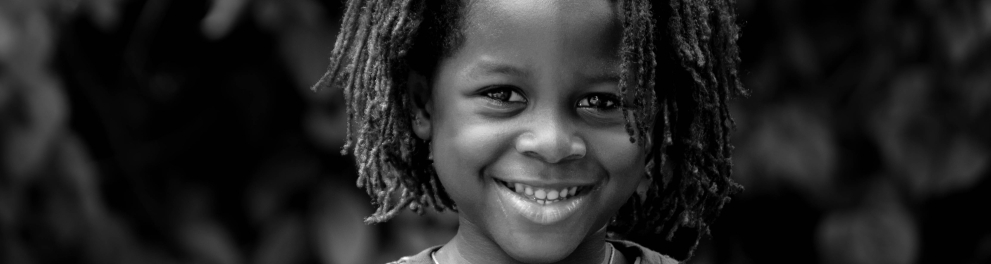 Um menino negro sorrindo para a foto