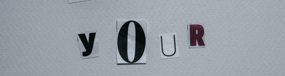 Letras cortadas de revistas ou jornais e colocadas sobre uma superfície branca formando a frase "use your voice"