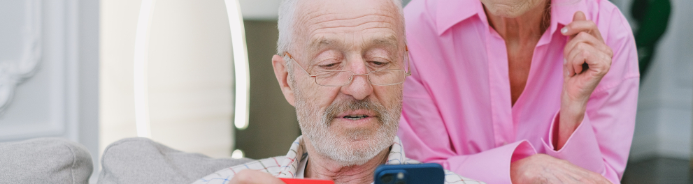 Dois idosos mexendo em um smartphone