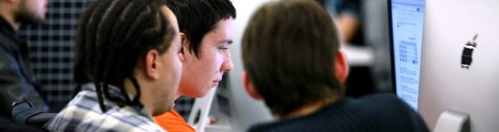 Três jovens mexendo em um computador