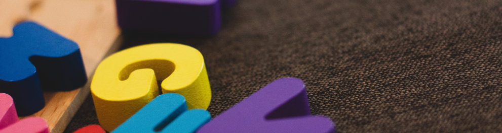 Letras coloridas do alfabeto sobre uma superfície plana de cor mais escura