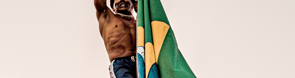 Imagem mostra uma pessoa indígena e bandeiras do Brasil