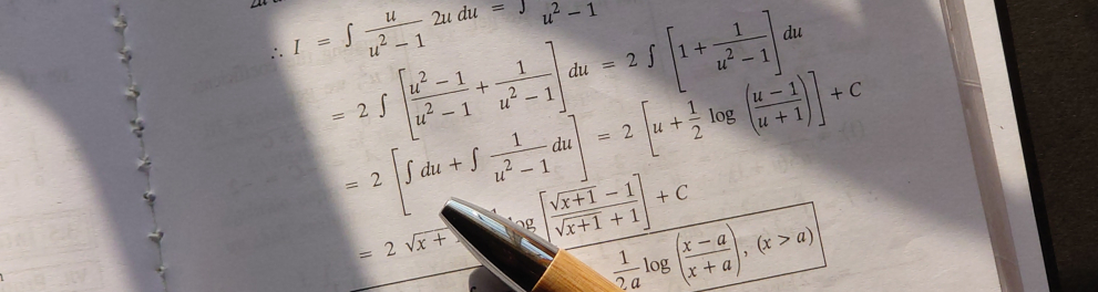 Um livro aberto em página com várias equações de matemática e uma caneta apoiada na página