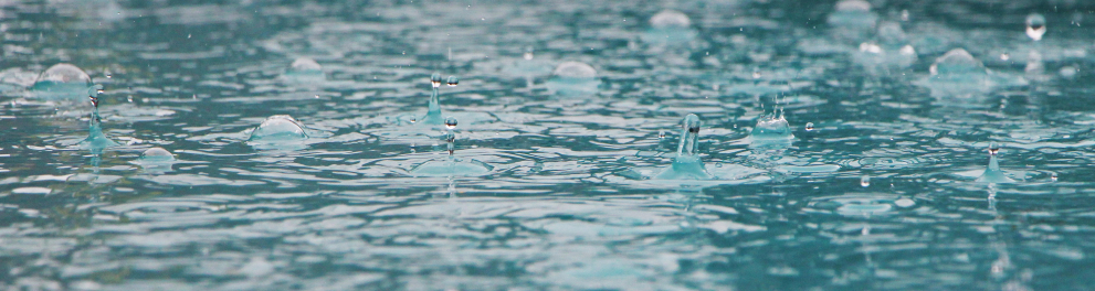 Imagem em close de pingos de chuva batendo em um provável mar