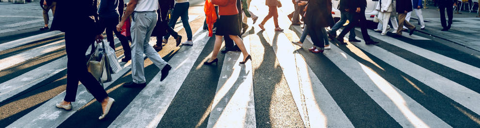Várias pessoas atravessando a rua na faixa de pedestres