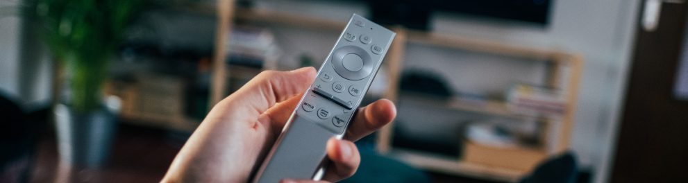 Uma pessoa mexendo em um controle remoto de televisão