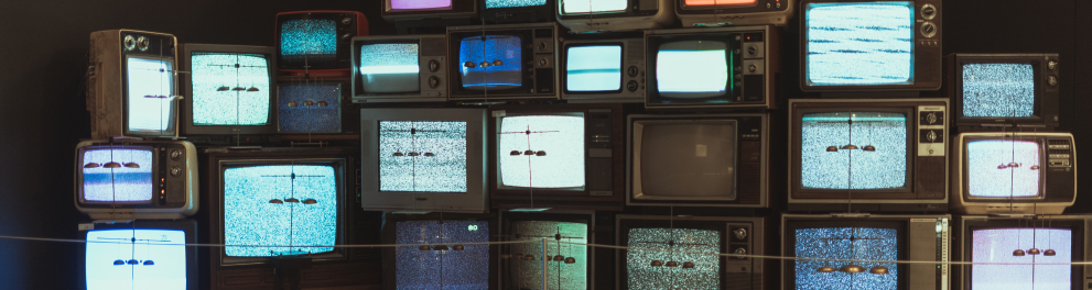 Várias aparelhos de televisão ligados e empilhados